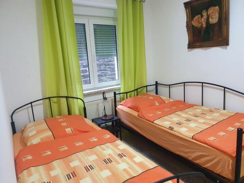 2 camas en una habitación con cortinas verdes en Ferienwohnung an der Fähre St. GOAR, en Sankt Goar