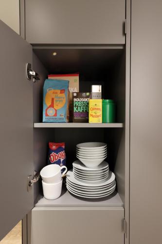 a cupboard filled with plates and bowls and dishes at Best Western Plus Ten Hotel in Upplands-Väsby