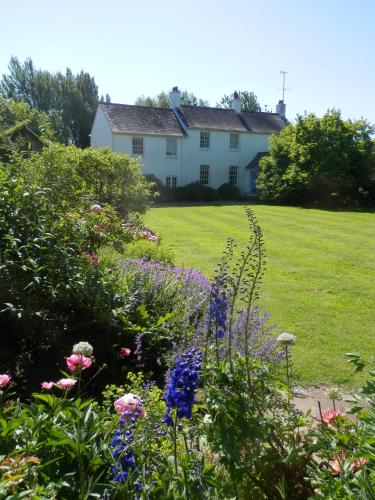 a garden with flowers in front of a house at The Naight House in Gloucester