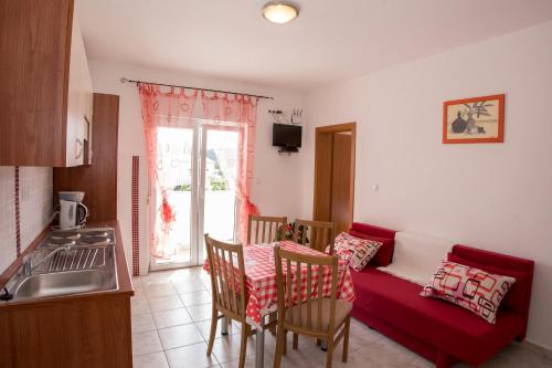 a kitchen with a couch and a table with chairs at Apartments Simona in Lopar