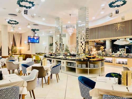 un restaurant avec des tables et des chaises ainsi qu'un bar dans l'établissement Hotel Orpheus - Casino and SPA, à Pamporovo