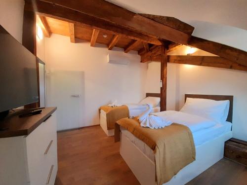 a bedroom with two beds and a television in it at Residence Mariánská in České Budějovice