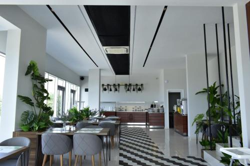 une salle à manger avec des tables, des chaises et des plantes dans l'établissement Green Hills Suites, à Yalova