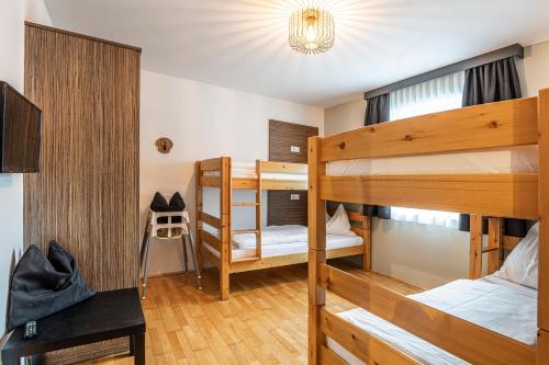 ヴァークラインにあるHaus Obauer by AlpenTravelの二段ベッド2台とシャンデリアが備わる客室です。