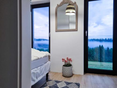 a bedroom with a door with a view of a lake at Koniakowo - dom Fino in Koniaków