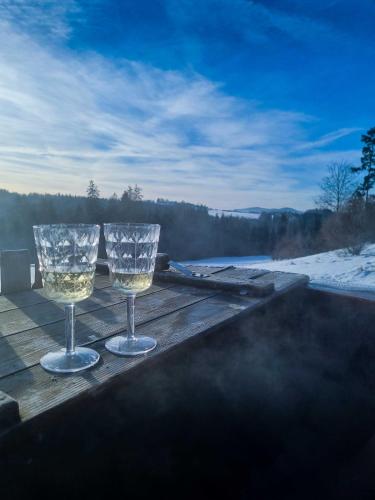 two wine glasses sitting on a table on a deck at Koniakowo - dom Fino in Koniaków