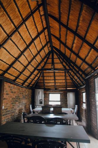 a room with a wooden ceiling with tables and chairs at Towers Lodge in Boksburg