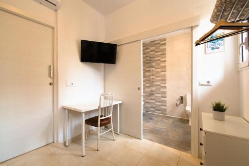 a room with a table and a television on the wall at Hostal El Perelló, Valencia in El Perelló