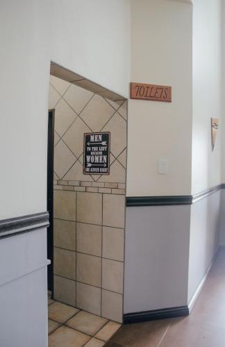 a room with a refrigerator and a sign on the wall at Towers Lodge in Boksburg