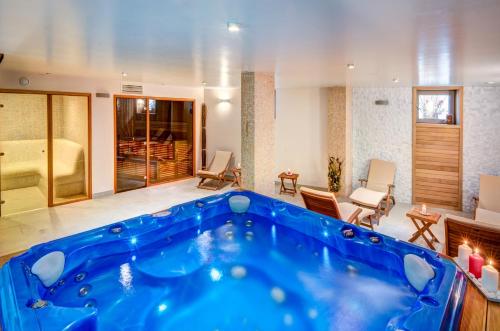 eine große blaue Badewanne in der Mitte eines Wohnzimmers in der Unterkunft Hotel & Relax Zone Cattleya in Krushuna