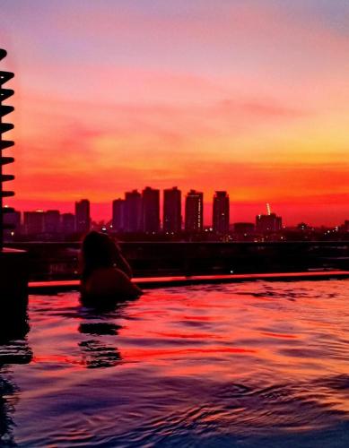a person in the water with a city in the background at The Sentinel Residences in Manila