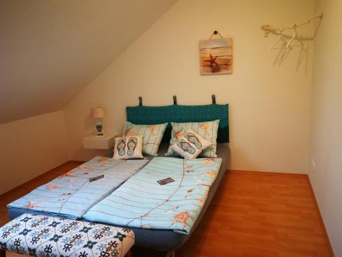 - un lit avec une couette bleue dans l'établissement Gästehaus Nord-West 1700 - Doppelzimmer Seestern, à Steenfeld