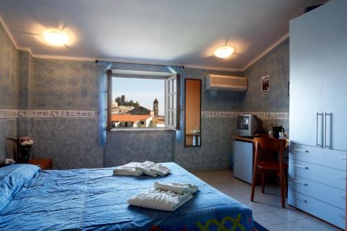 a bedroom with a bed and a kitchen with a window at Hotel Food & Drink in Altomonte