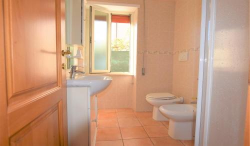 une salle de bain avec un lavabo et des toilettes et une fenêtre dans l'établissement Primavera, à Marina di Campo