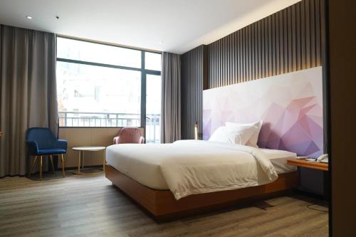 a bedroom with a bed and a large window at Joy Hotel in Phnom Penh