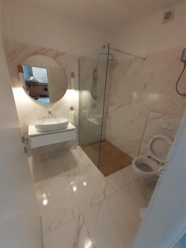 a white bathroom with a sink and a toilet at Barko apartment and rooms in Hvar