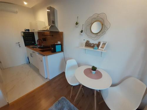 una mesa blanca y sillas en una cocina con espejo en Barko apartment and rooms en Hvar