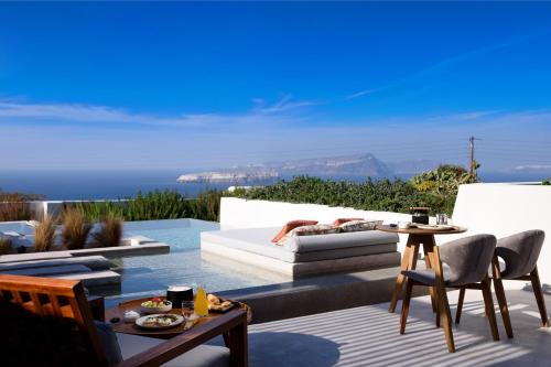une terrasse avec un canapé blanc et une table dans l'établissement Potnia Theron Suites, à Akrotiri