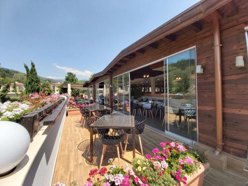 a patio with tables and flowers on a building at Pirin Park Hotel in Sandanski