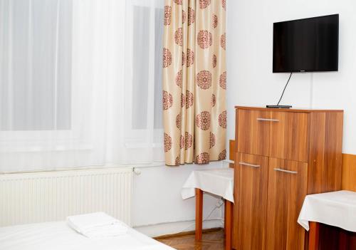 a room with a tv on a cabinet and a curtain at Casa Zâna Bună in Gherla
