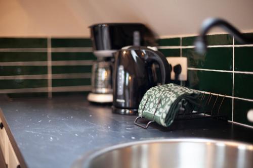 a kitchen counter with a sink and a coffee pot at Luxury Suites Meir by Rikas Hotels in Antwerp