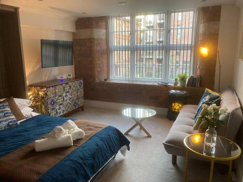 48 Cocoa Suites, York City Centre في يورك: غرفة معيشة مع سرير وأريكة