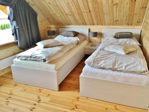 - 2 lits dans une chambre dotée de parquet dans l'établissement Chata Natan, à Veľká Lomnica
