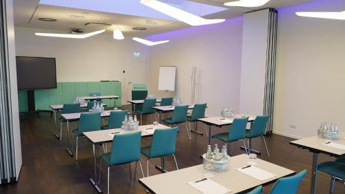 a classroom with tables and chairs and a tv at Grimm´s Berlin Potsdam in Teltow
