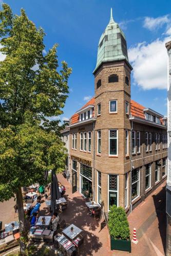 a building with a clock tower on top of it at Hotel de Koppelpaarden in Lichtenvoorde