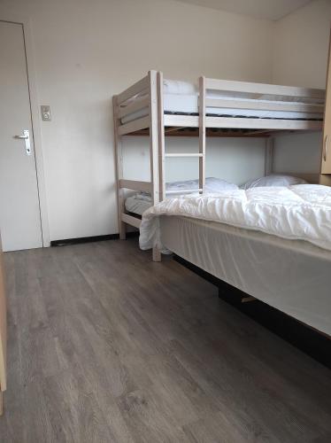 a bedroom with a bunk bed and a wooden floor at 't Calmeyntje in De Panne