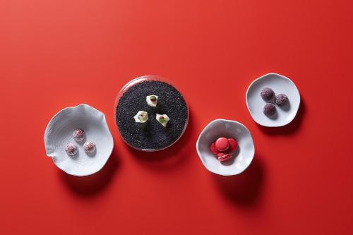 four dishes of food on a red background at Steigenberger Icon Parkhotel Düsseldorf in Düsseldorf