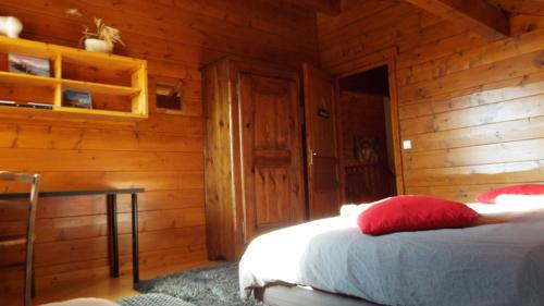 a bedroom with a bed in a log cabin at Chambre d'Hôtes Barnabas in Saint-Martin-de-la-Porte