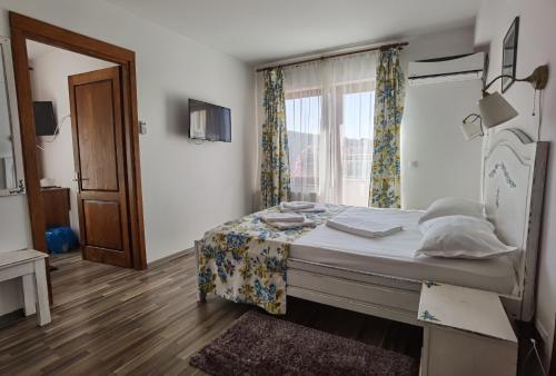 a bedroom with a bed and a window at Pensiunea Geostar in Curtea de Argeş
