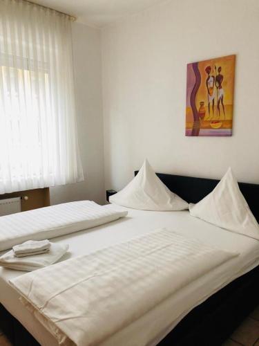 2 weiße Betten in einem Schlafzimmer mit Wandgemälde in der Unterkunft Hotel im Brühler Hof in Brühl