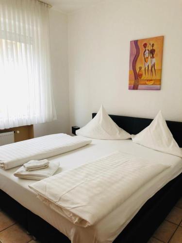 2 weiße Betten in einem Schlafzimmer mit Wandgemälde in der Unterkunft Hotel im Brühler Hof in Brühl