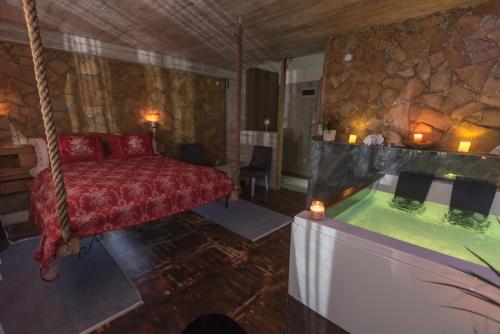 a room with a bed and a tub in it at Onore dell amore 2 apartman sa djakuzijem in Banja Koviljača