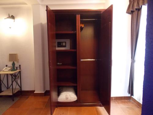 a wooden book shelf in a living room at Hotel Real de Leyendas in Guanajuato