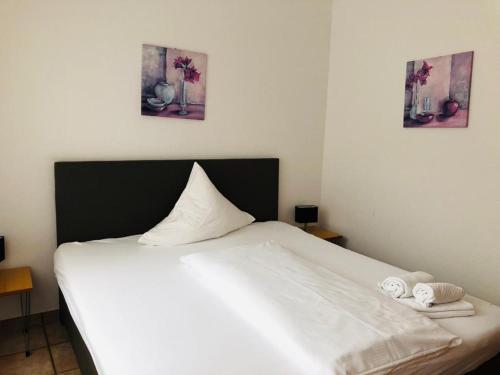 ein weißes Bett mit zwei Handtüchern darüber in der Unterkunft Hotel im Brühler Hof in Brühl