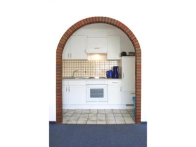 una cocina con un arco en el medio de una habitación en Haus Seestern, en Neuharlingersiel