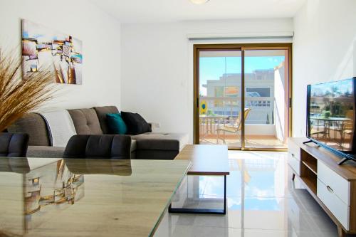 un soggiorno con divano e TV di Phaedrus Living City View Luxury Flat Georgos 203 a Paphos