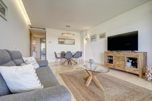 a living room with a couch and a flat screen tv at Ribera del Marlin - Sotogrande in Sotogrande