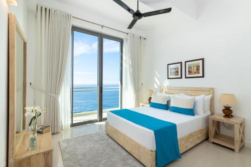 una camera con un letto e una grande finestra di Oceanfront Condominiums Galle a Galle