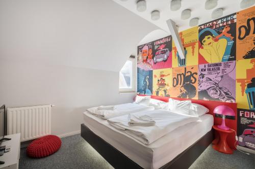 Schlafzimmer mit einem Himmelbett an der Wand in der Unterkunft Butik Apartments, by BQA in Budapest