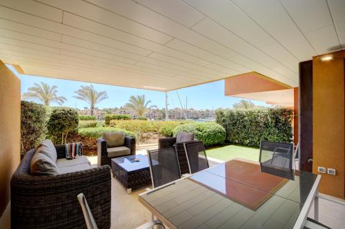a living room with a glass table and chairs at Ribera del Marlin - Sotogrande in Sotogrande