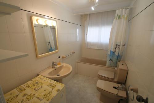 a bathroom with a toilet and a sink and a mirror at Apartamento Villa Adriana 205 in Miami Platja