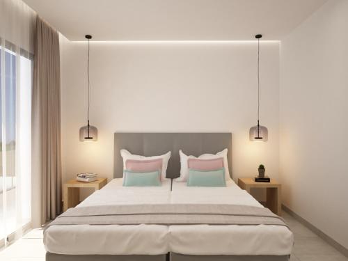 a bedroom with a large bed with pink and blue pillows at Lord Complex in Agios Georgios