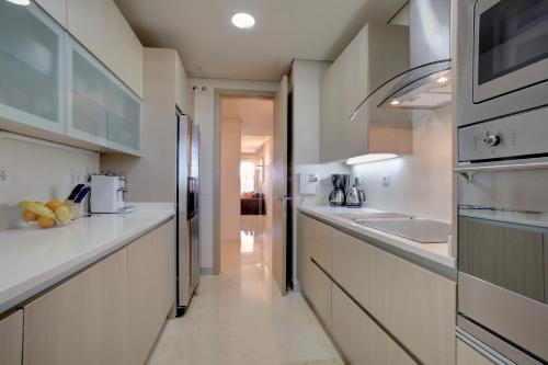 a kitchen with white cabinets and a counter top at Ribera del Marlin - Sotogrande in Sotogrande