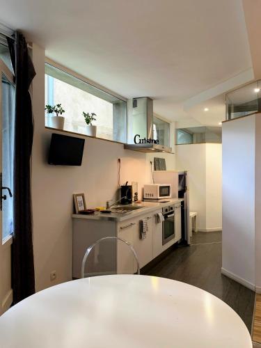 une cuisine avec une table et un comptoir blanc dans l'établissement Les Pénates de Loire, à Ancenis