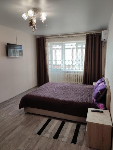 1 dormitorio con cama morada y ventana en Аренда квартиры, en Izmaíl