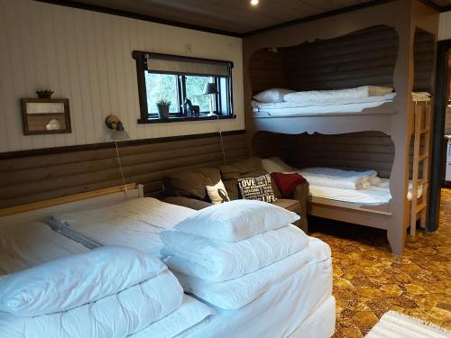 a bedroom with three bunk beds and a window at Backlund Boende i Dalarna in Rättvik
